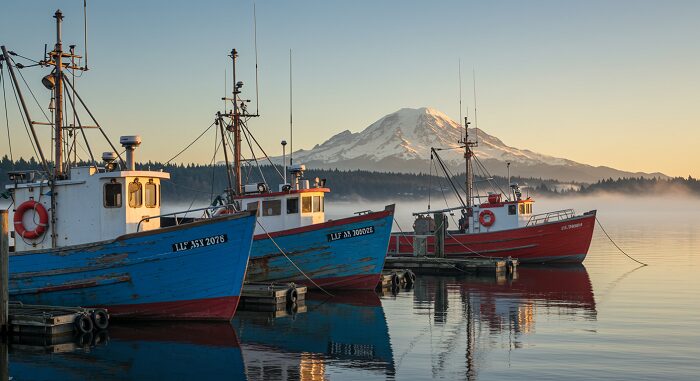 Seattle fishing boats with Mount Rainier backdrop, essential stop on 7-day Pacific Northwest itinerary